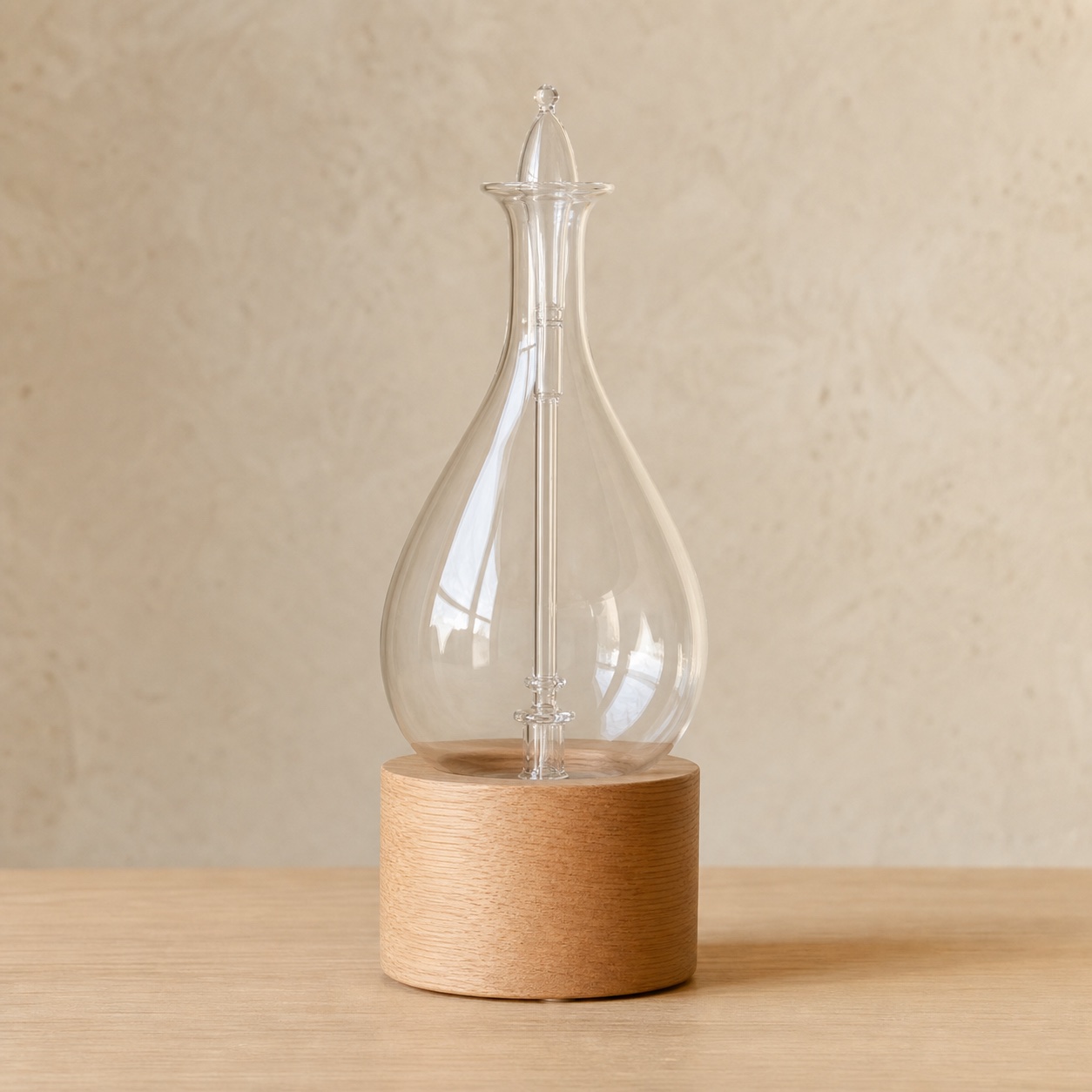 AI-generated representation of a clear glass nebulizing diffuser on a light wood base resembling the Organic Aromas Raindrop 2.0