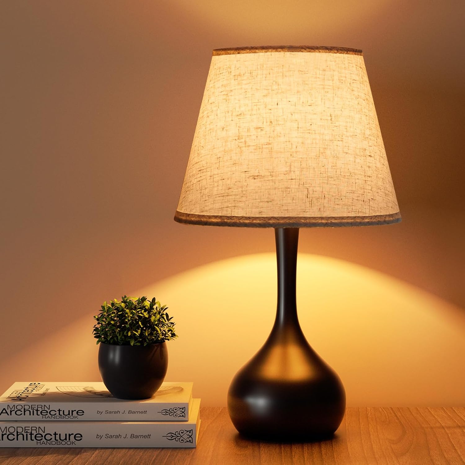 Warm table lamp with a textured linen shade and dark base